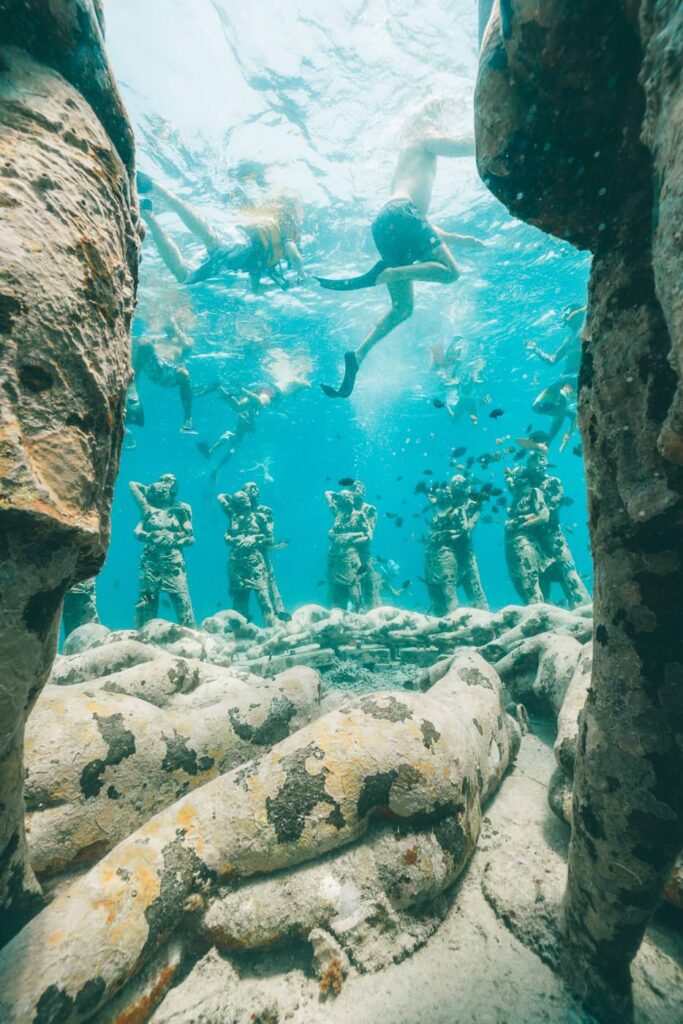 Gili Meno Underwater Statues: A Local's Guide to the Nest 6 Snorkellers above the Gili Meno statues, seen through a rock arch