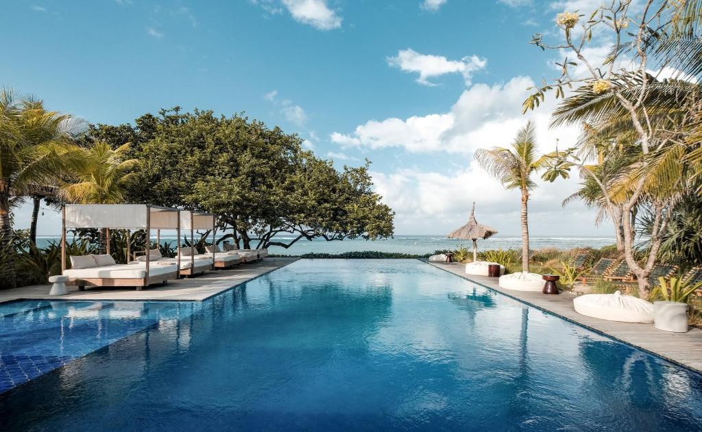 Outdoor pool overlooking the ocean with lounge chairs Amber Lombok Beach Resort