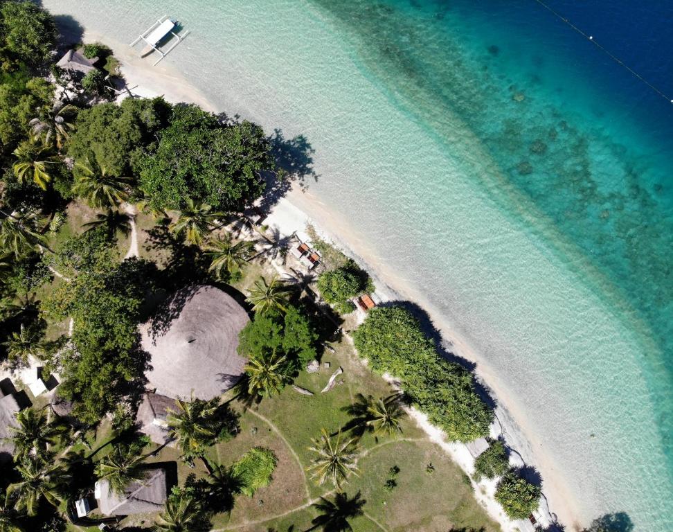 Aerial views over Eco Lodge with reef and clear water for swimming