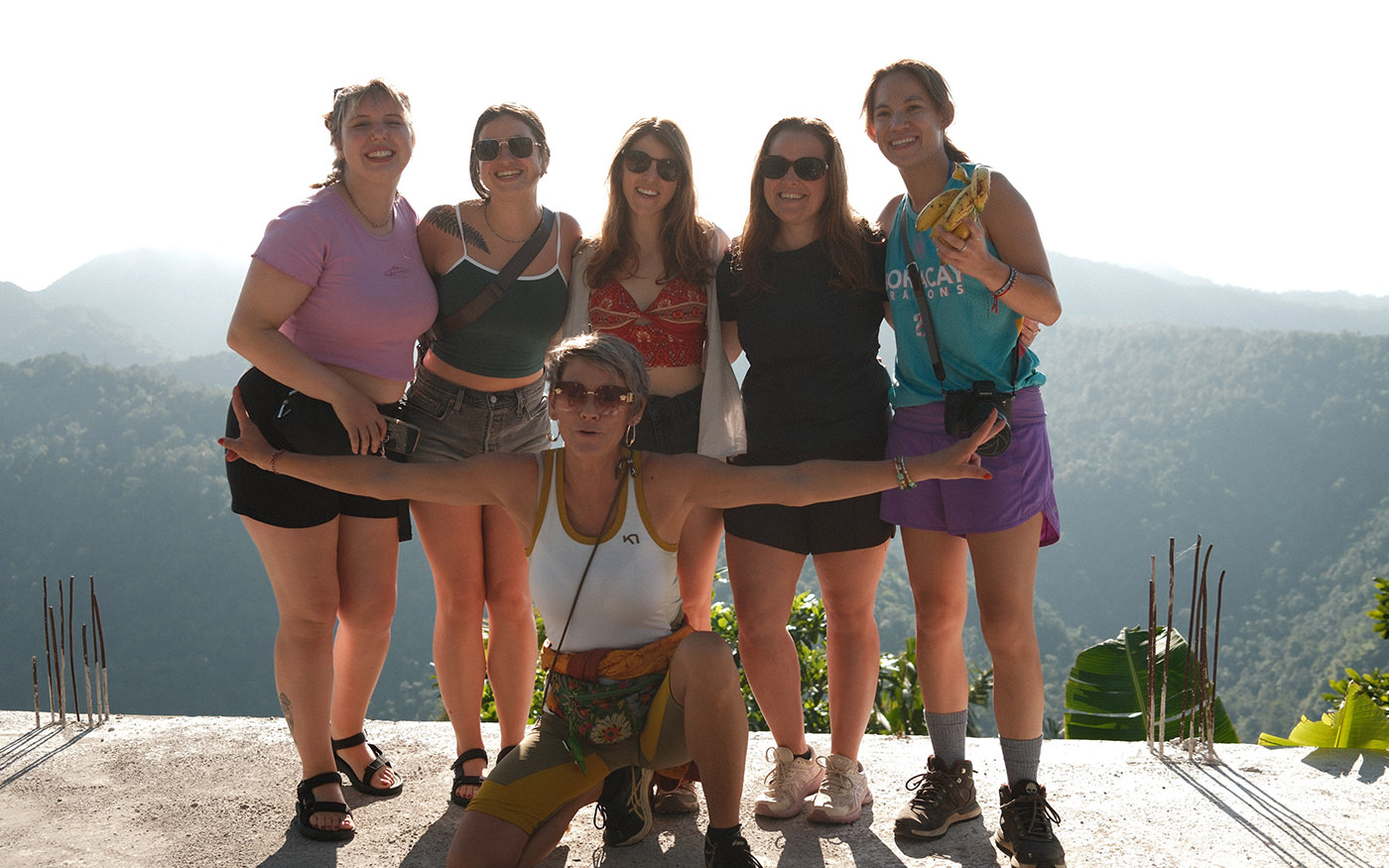 Group of travellers standing at a viewpoint over green hills in Lombok