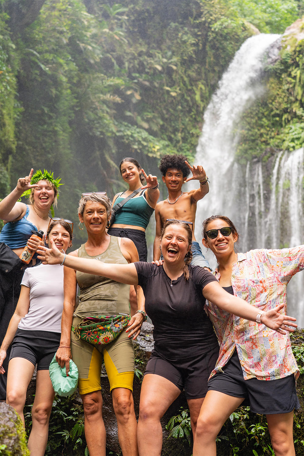 Group of travellers standing in front of a waterfall in Lombok during the wet season
