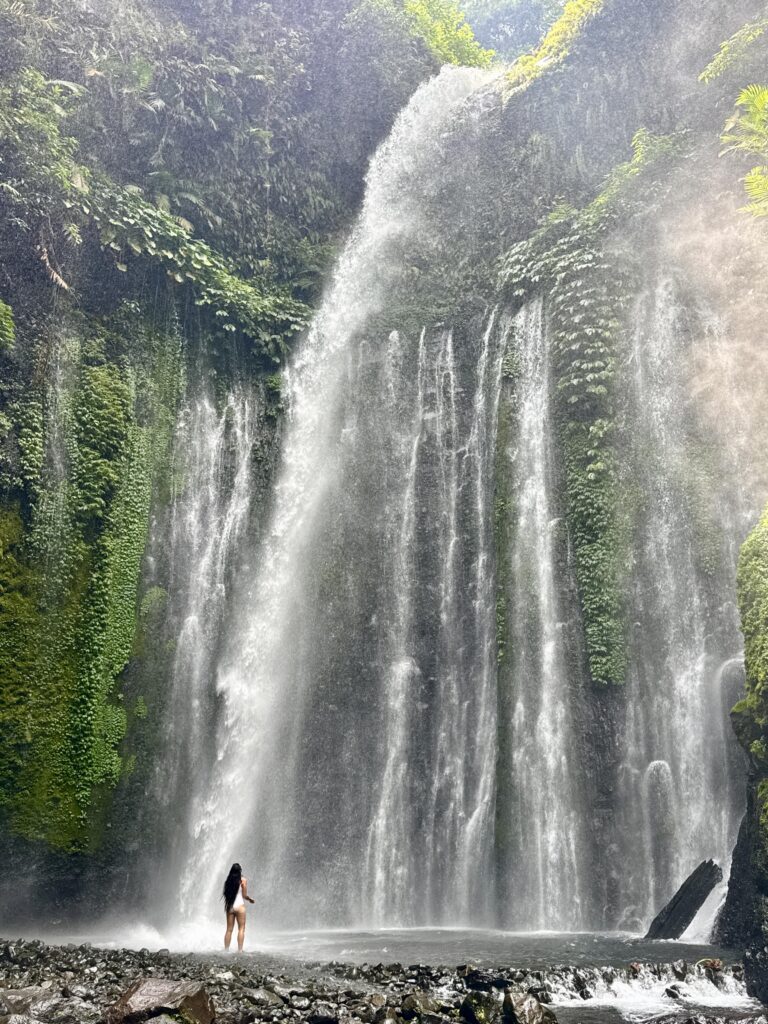 Haylea standing under the Tiu Kelep Waterfall 