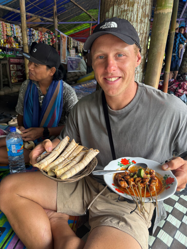 Lombok River tubing: How to Visit Bawak Goak Sesaot 15 Olly holding the food satay chicken and rice