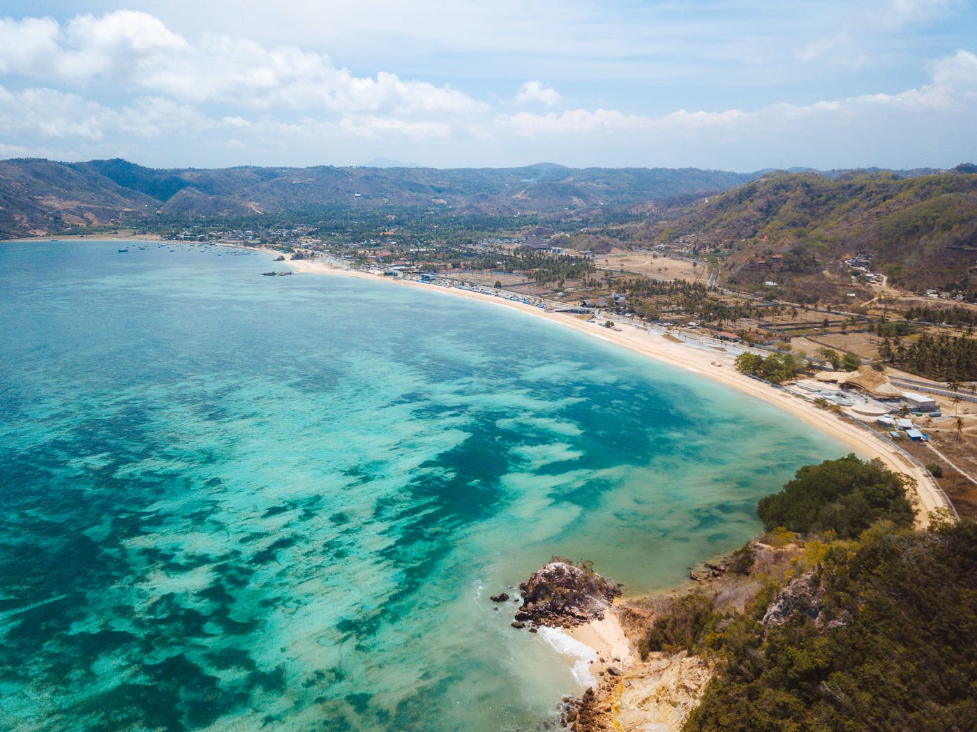 Kuta Beach in Kuta Lombok with the town esplanade and shallow reef bay at low tide