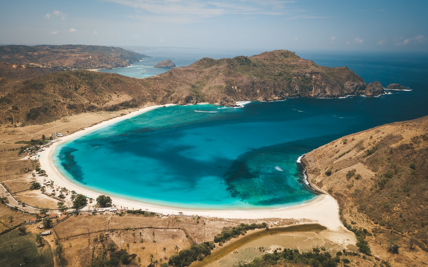 Aerial view of a white sand bay on the south coast of Lombok near Kuta with green headlands either side