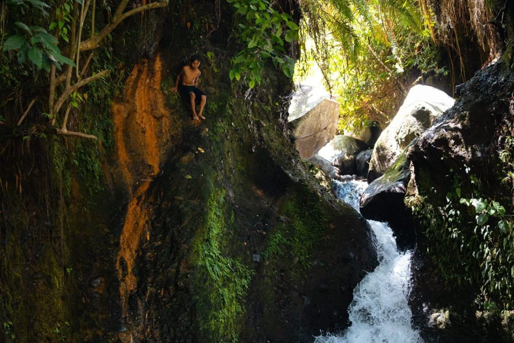 Tetebatu Waterfall (Durian Indah): A Local's Guide 14 Local kid climbing the rock beside Durian Indah waterfall towards the cliff jump spot